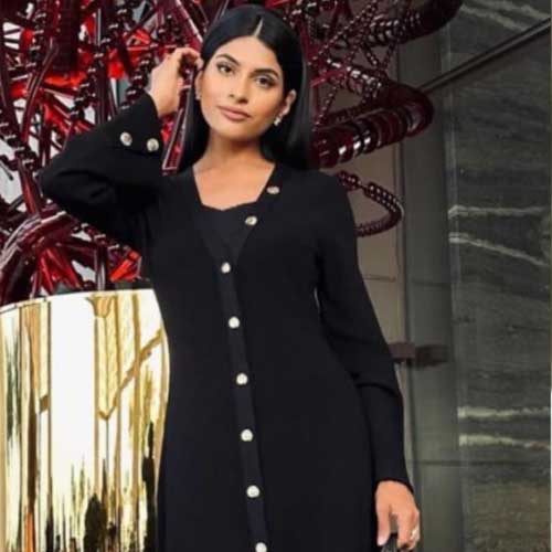Farhana Bodi wearing Nira Black Knit Dress: Elegant V-Neck with Gold Shell Buttons